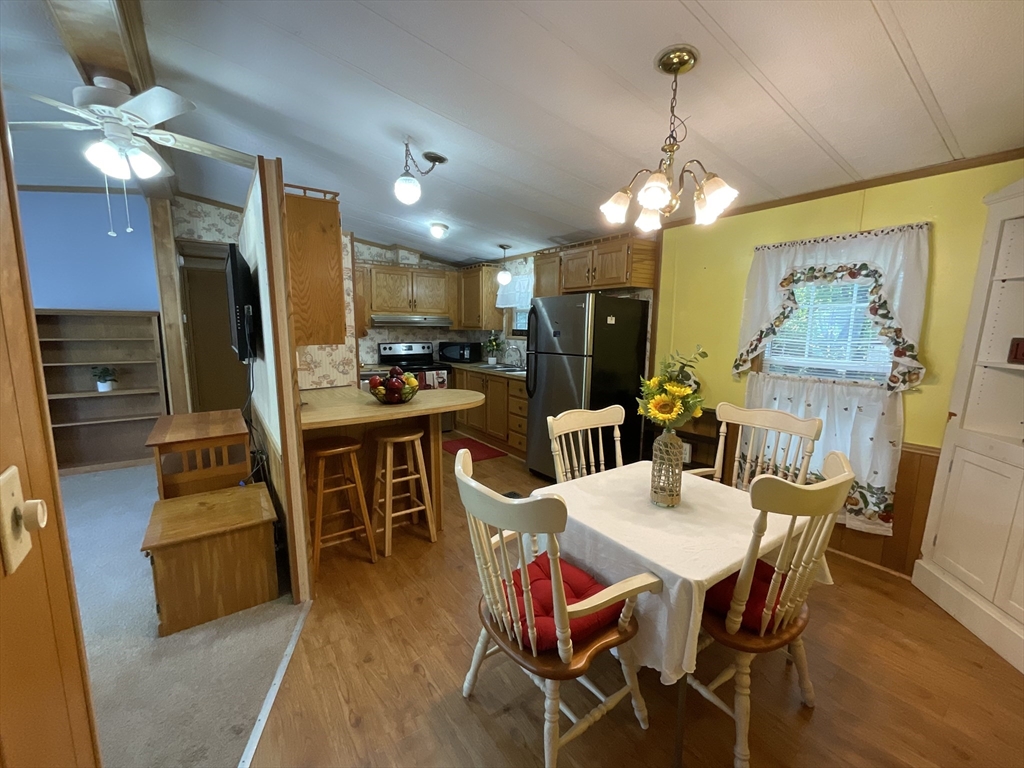 16 Agent Road Raymond, NH 03077 - Photo 26 of 35 a view of a dining room with furniture a chandelier and wooden floor