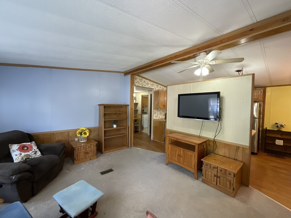 16 Agent Road Raymond, NH 03077 - Photo 28 of 35 a living room with furniture and a flat screen tv