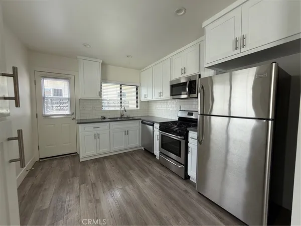 a kitchen with stainless steel appliances a refrigerator sink and cabinets