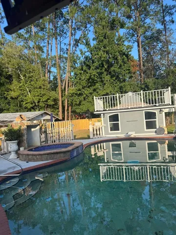 a view of a house with a wooden deck and a yard
