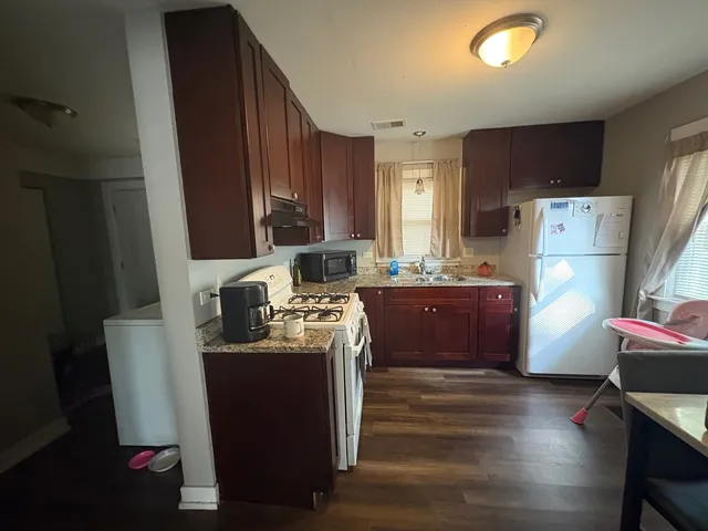 a kitchen with stainless steel appliances granite countertop a refrigerator a stove a sink and a refrigerator