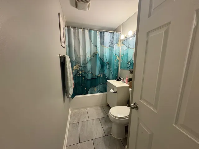a bathroom with a toilet and a shower