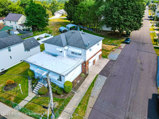 an aerial view of a house with swimming pool garden and patio