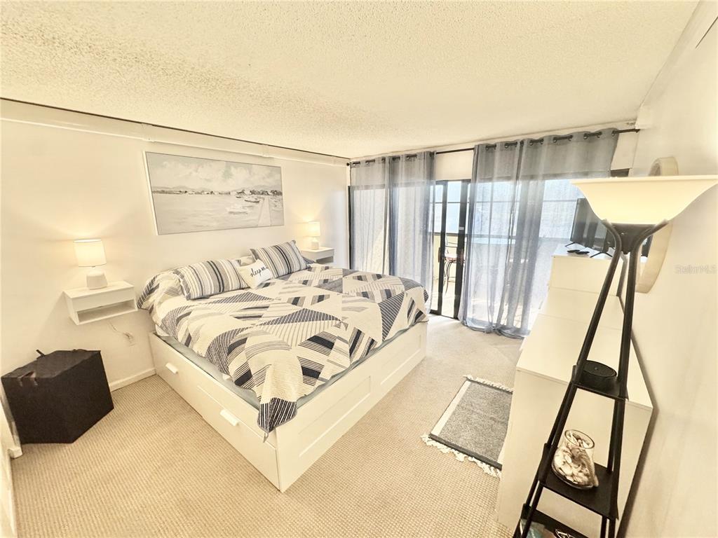 3170 Matecumbe Key Road, Unit 115 Punta Gorda, FL 33955 - Photo 12 of 43 a spacious bedroom with a bed and a couch