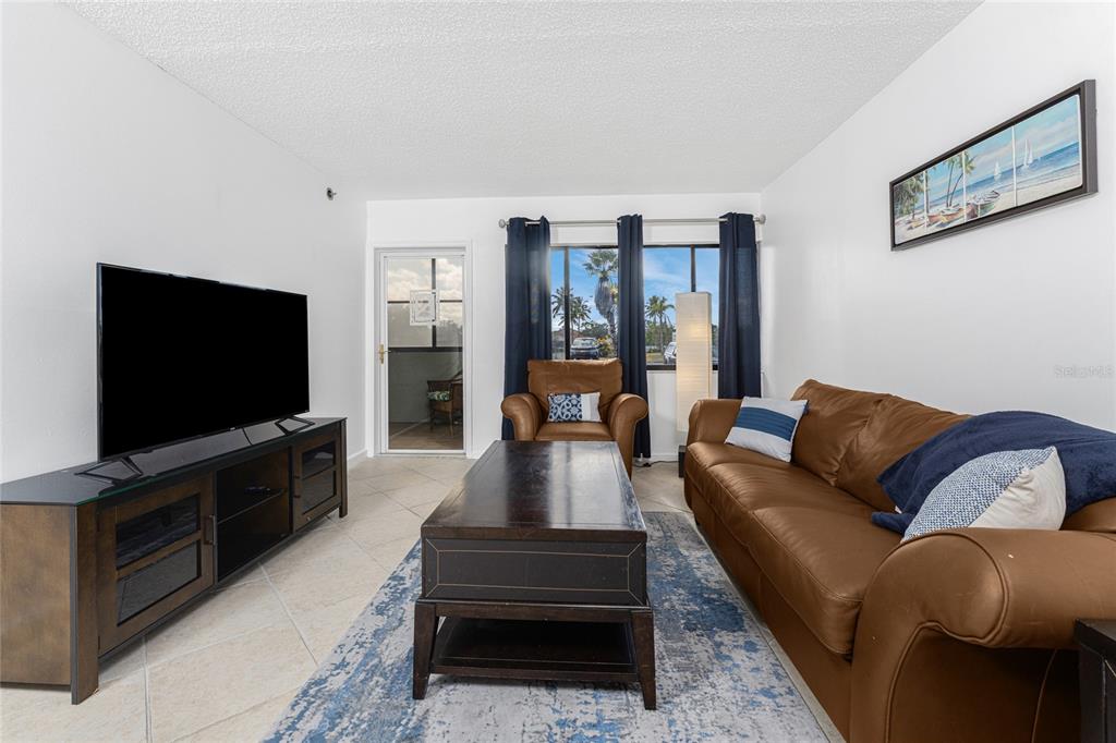 3170 Matecumbe Key Road, Unit 115 Punta Gorda, FL 33955 - Photo 13 of 59 a living room with furniture and a flat screen tv