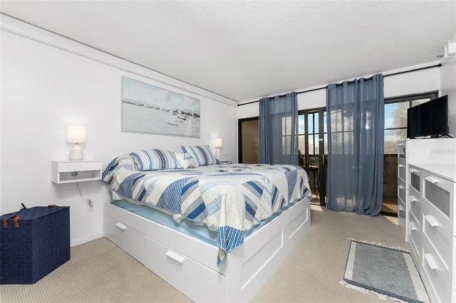 a spacious bedroom with a bed and a flat screen tv