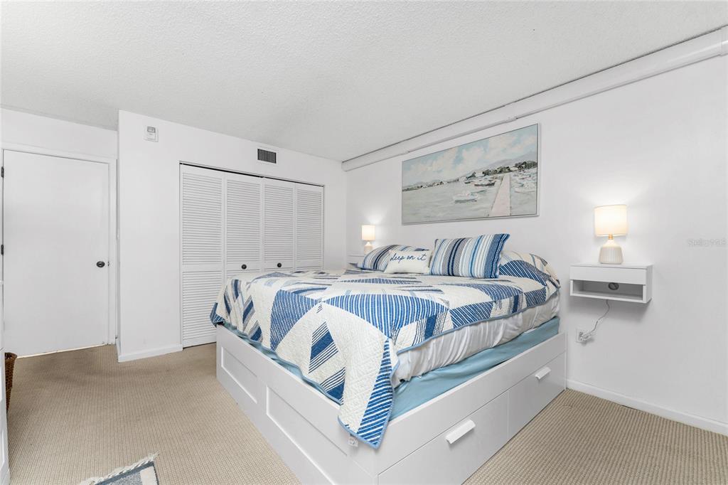 3170 Matecumbe Key Road, Unit 115 Punta Gorda, FL 33955 - Photo 21 of 59 a spacious bedroom with a bed and a cabinets
