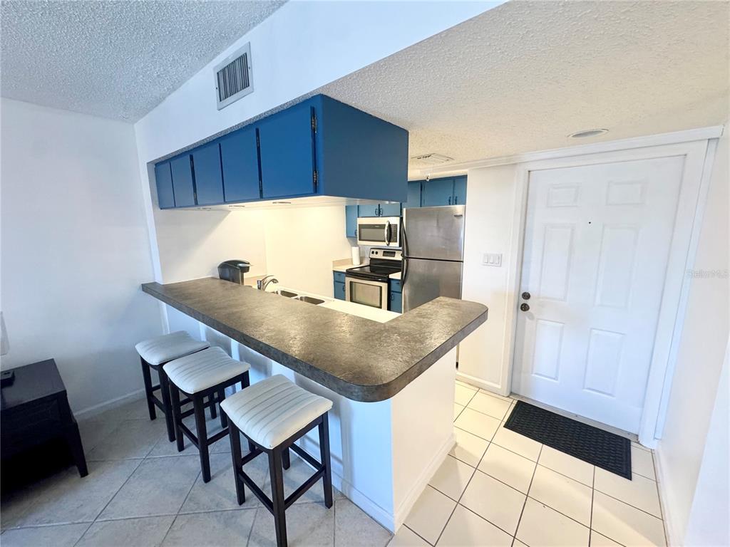 3170 Matecumbe Key Road, Unit 115 Punta Gorda, FL 33955 - Photo 4 of 43 a kitchen with stainless steel appliances a table and chairs in it