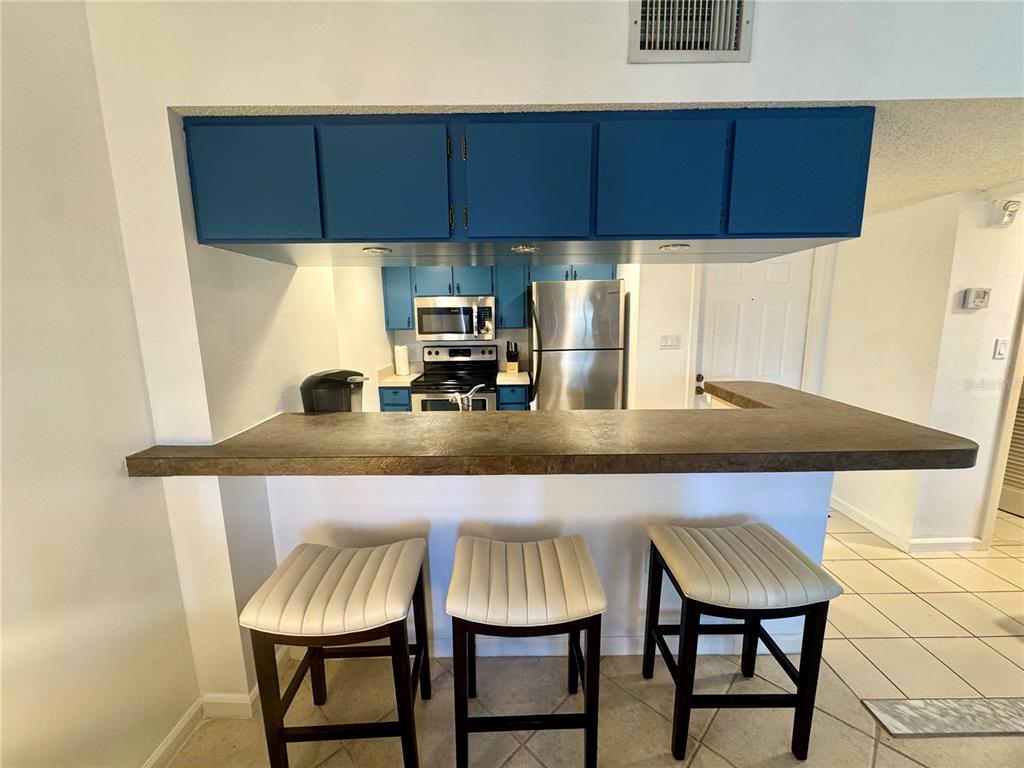 3170 Matecumbe Key Road, Unit 115 Punta Gorda, FL 33955 - Photo 5 of 43 a kitchen with a table chairs and a stove