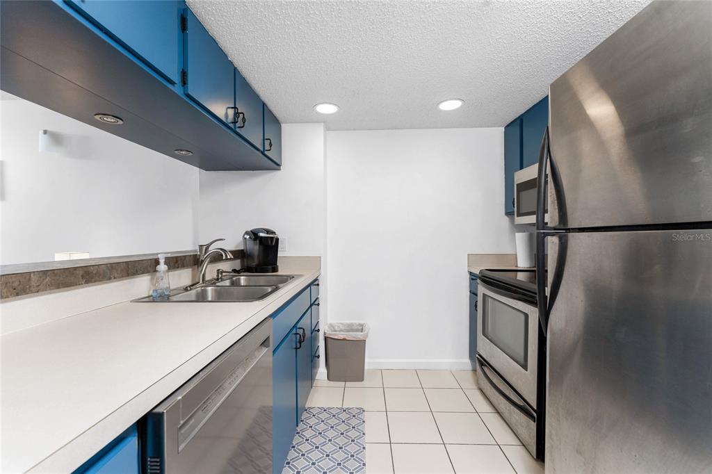 3170 Matecumbe Key Road, Unit 115 Punta Gorda, FL 33955 - Photo 8 of 59 a kitchen with stainless steel appliances granite countertop a sink refrigerator and microwave