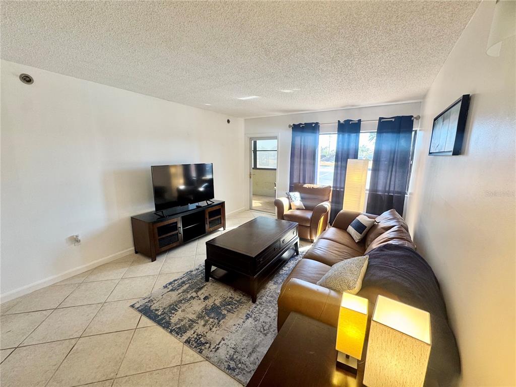 3170 Matecumbe Key Road, Unit 115 Punta Gorda, FL 33955 - Photo 9 of 43 a living room with furniture and a flat screen tv