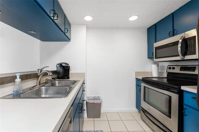 a kitchen with sink a microwave a stove and refrigerator