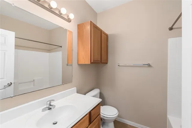 an empty room with windows and ceiling fan