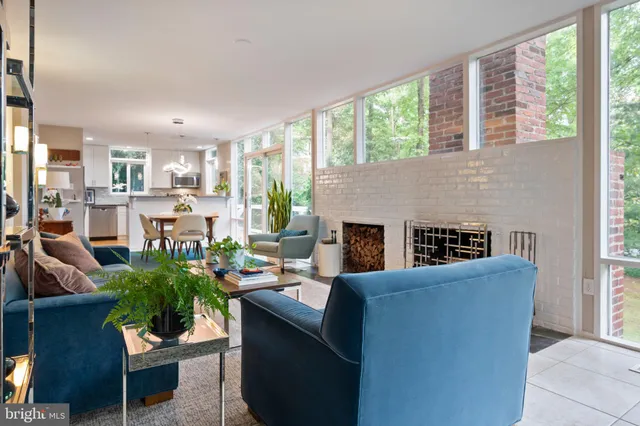 a living room with furniture a large window and a fireplace