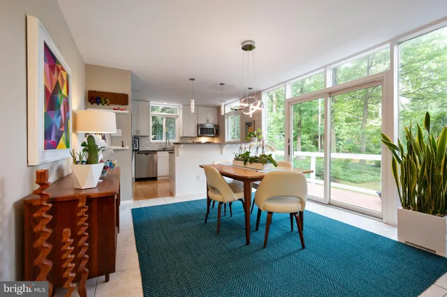 a dining room with furniture a rug and a floor to ceiling window