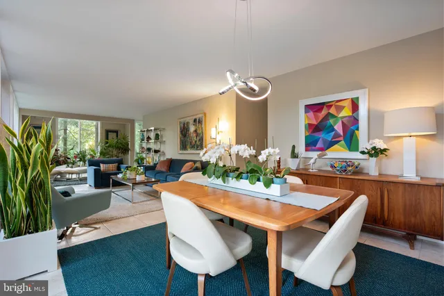 a view of a dining room with furniture one side kitchen view and wooden floor