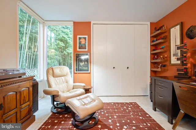 a living room with furniture and a floor to ceiling window