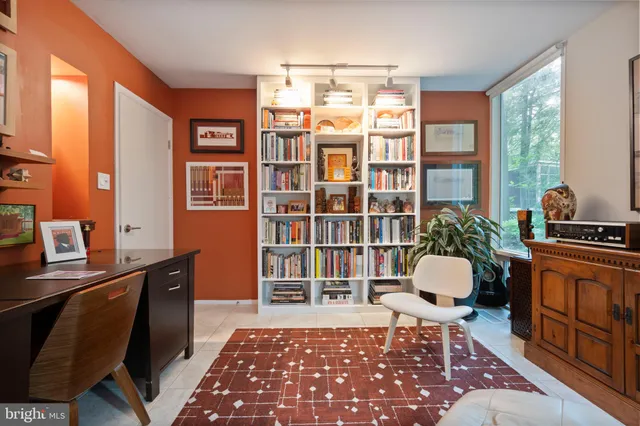 a living room with furniture a rug and a bookshelf