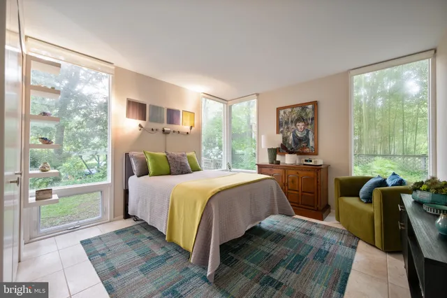 a bedroom with a bed and large windows