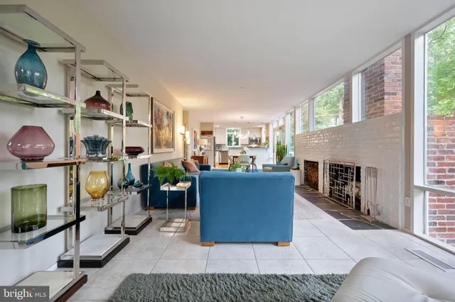 a living room with furniture a fireplace and a floor to ceiling window