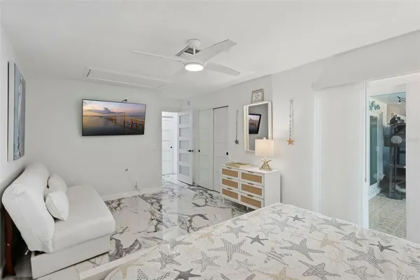 a spacious bedroom with a bed and a flat screen tv