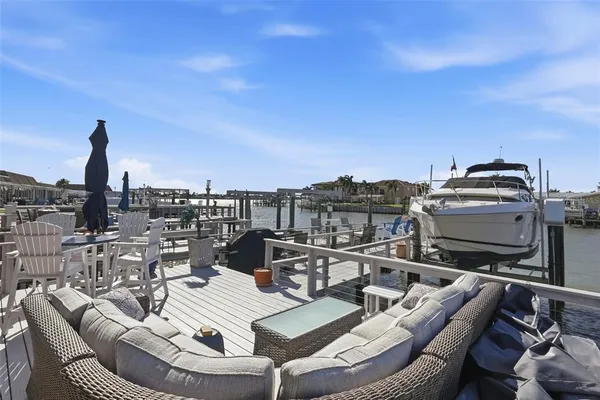 a view of a rooftop deck with chairs and wooden floor