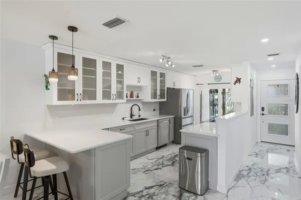 a kitchen with white cabinets and stainless steel appliances