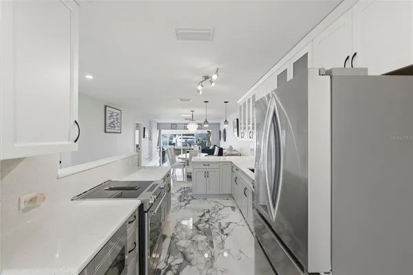 a kitchen with white cabinets and refrigerator