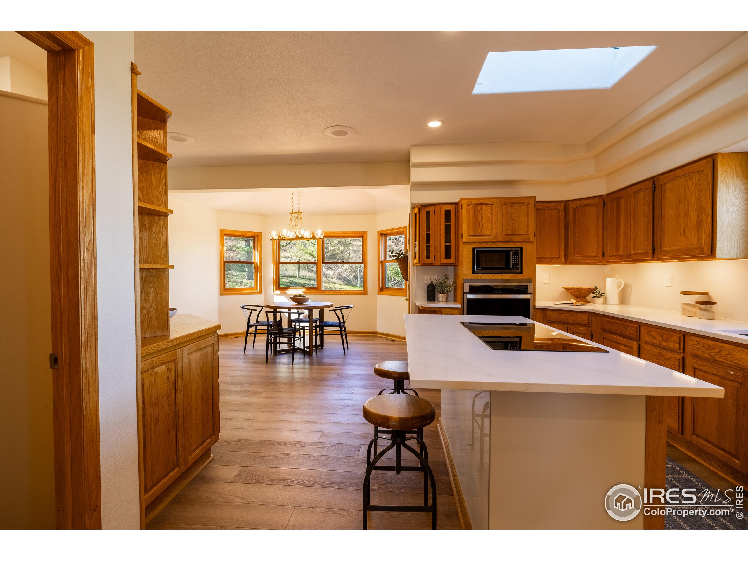 6465 Hidden Springs Road Fort Collins, CO 80526 - Photo 18 of 50 a kitchen with a table chairs refrigerator and cabinets