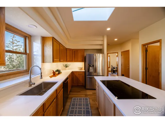a kitchen with a sink a counter top space and stainless steel appliances