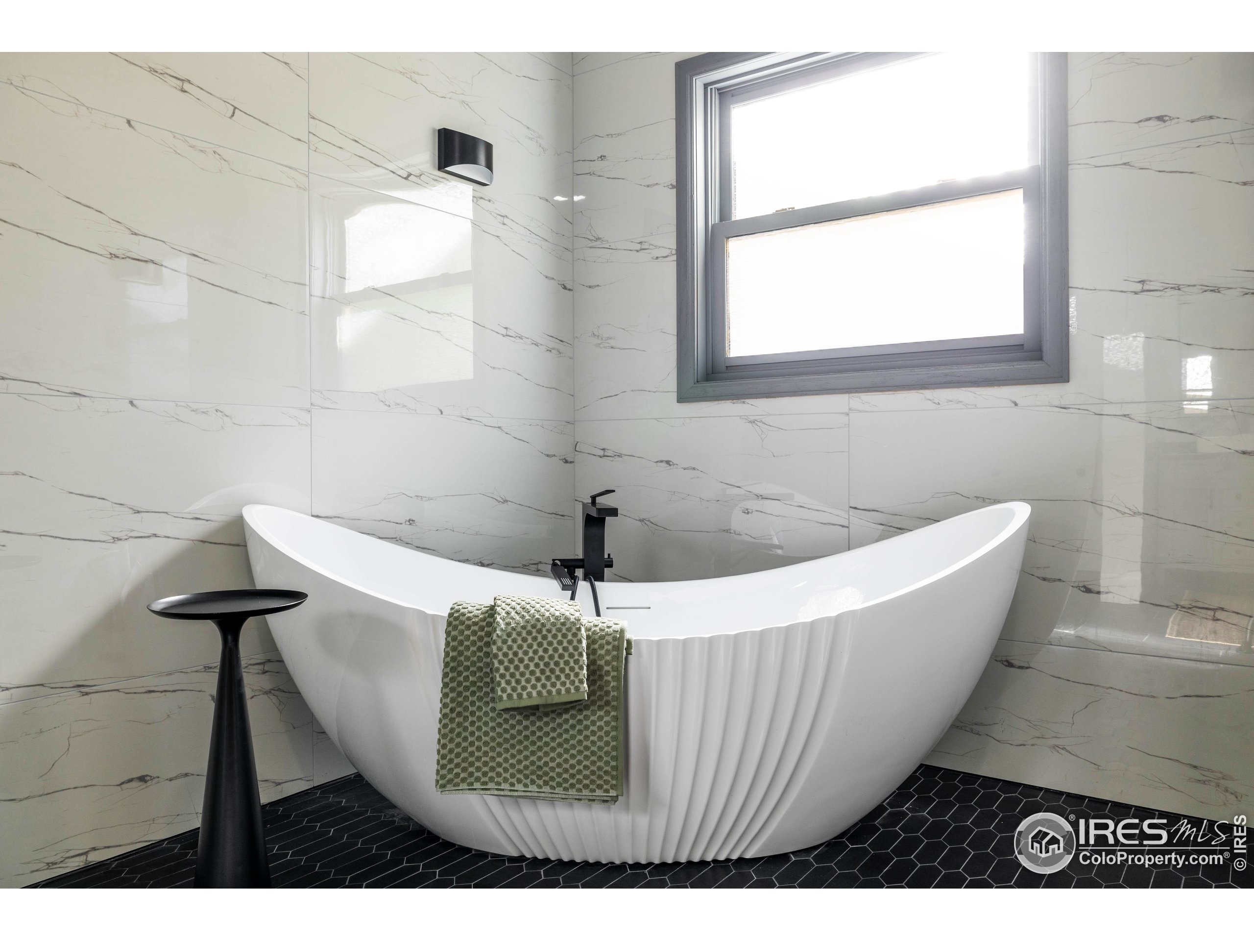 6465 Hidden Springs Road Fort Collins, CO 80526 - Photo 26 of 50 a bath tub sitting in a bathroom next to a window