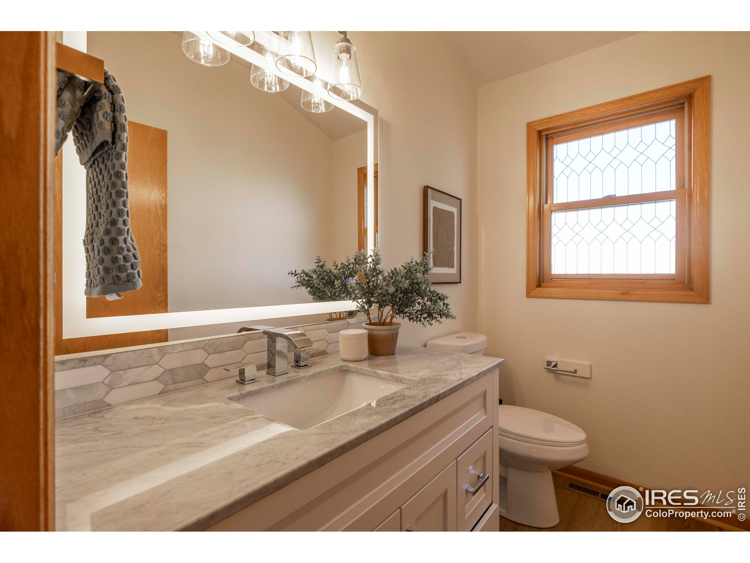 6465 Hidden Springs Road Fort Collins, CO 80526 - Photo 34 of 50 a bathroom with a granite countertop sink a toilet and a mirror