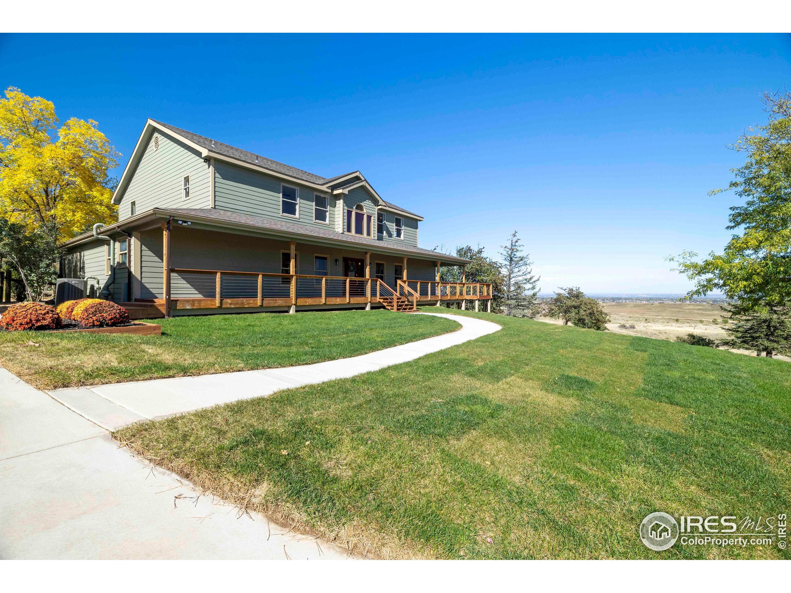 6465 Hidden Springs Road Fort Collins, CO 80526 - Photo 48 of 50 a view of a white house with a big yard and potted plants