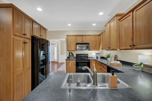 a kitchen with stainless steel appliances granite countertop a refrigerator and a stove top oven