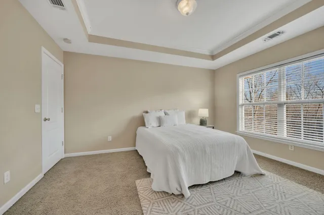 a bedroom with a bed and a large window