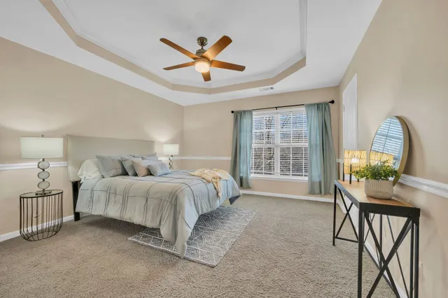 a spacious bedroom with a bed a chandelier and a window