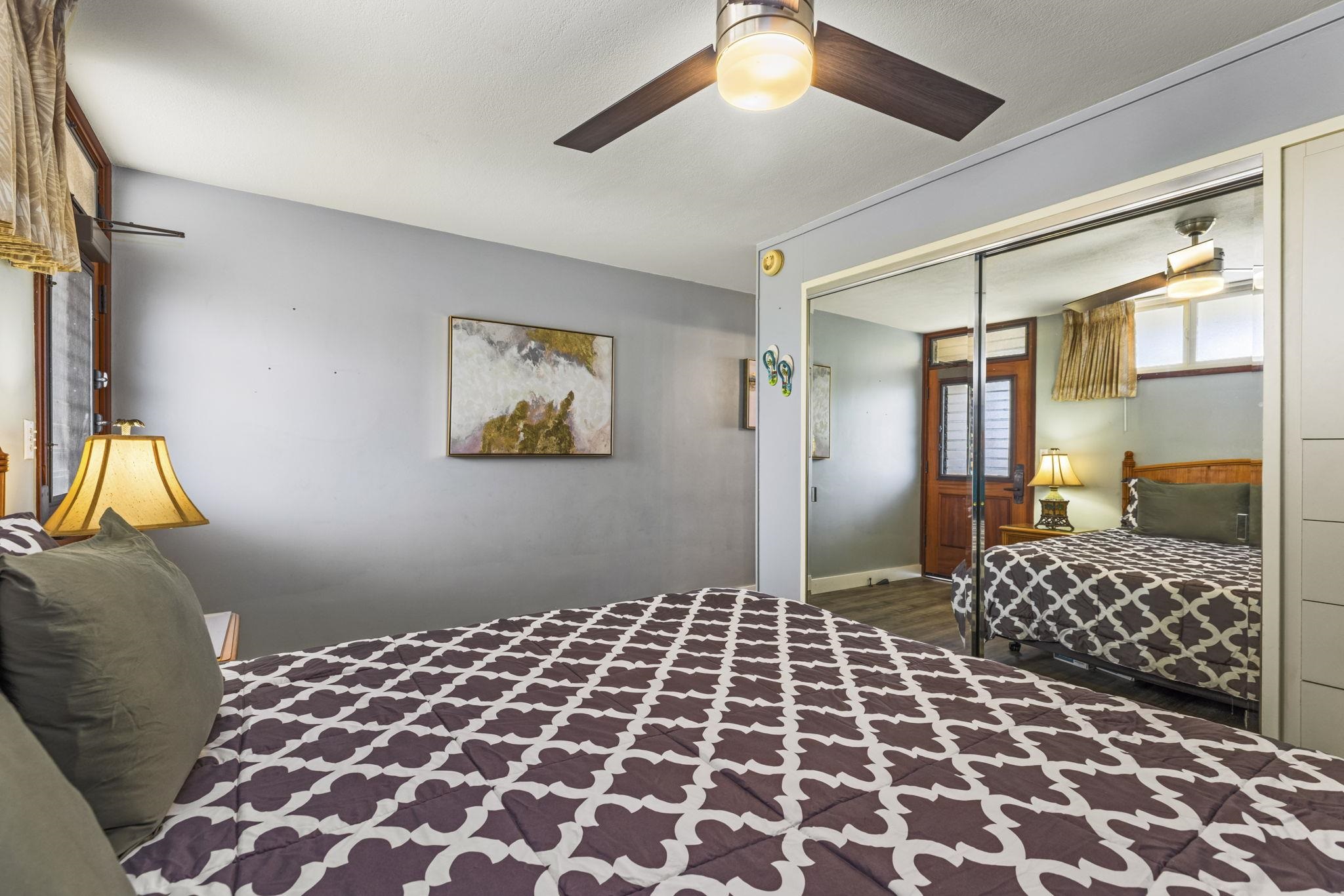 1310 Uluniu Road, Unit 317 Kihei, HI 96753 - Photo 29 of 50 a bedroom with a bed and a lamp on dresser