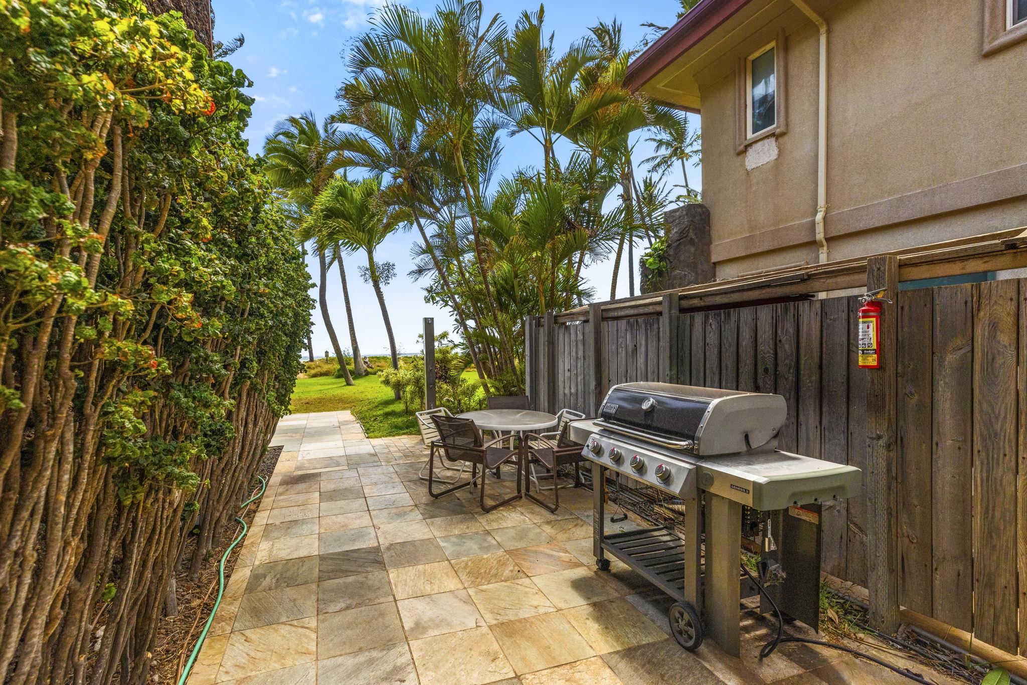 1310 Uluniu Road, Unit 317 Kihei, HI 96753 - Photo 33 of 50 a view of a patio with table and chairs with wooden fence and plants