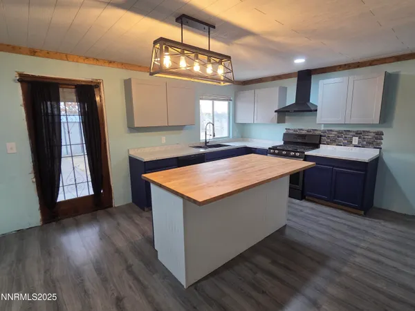 a kitchen with stainless steel appliances granite countertop a stove a sink dishwasher a refrigerator and a stove with wooden floor