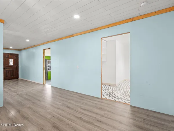 a view of an empty room with wooden floor