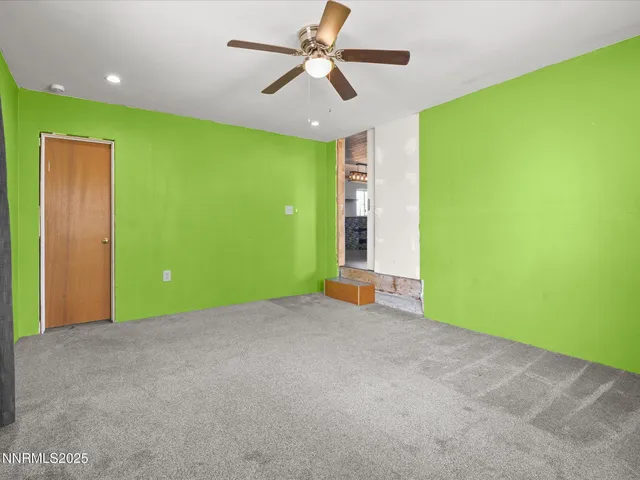 a view of a big room with potted plants and a ceiling fan
