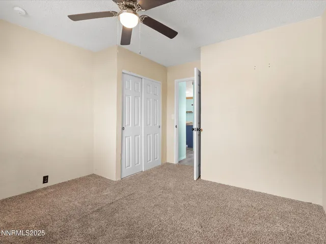 an empty room with a ceiling fan and a window