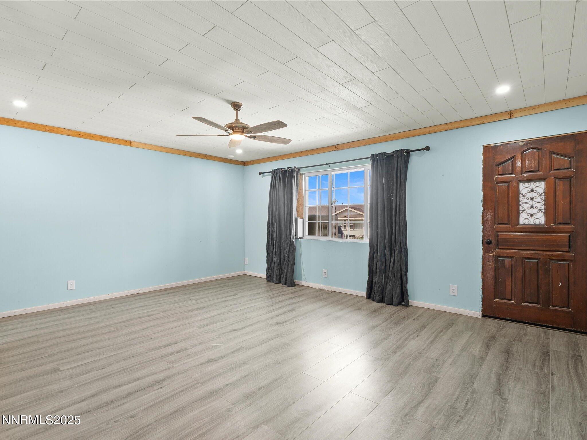 845 Mc Lean Street Fallon, NV 89406 - Photo 5 of 23 a view of an empty room with window and wooden floor