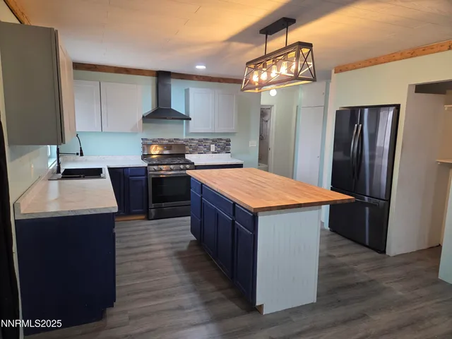 a kitchen with kitchen island a sink wooden floor and stainless steel appliances