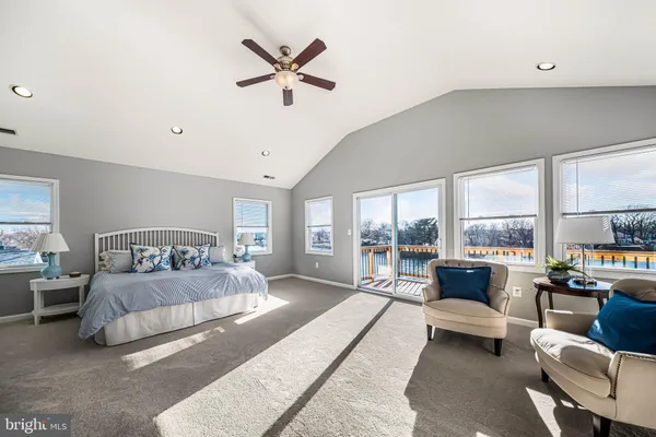 a bedroom with a large bed couch and a large window