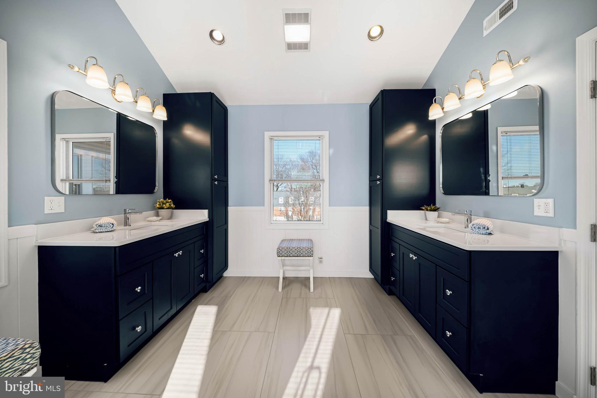 8101 Shore Road Baltimore, MD 21222 - Photo 16 of 35 a spacious bathroom with a double vanity sink and mirror with shower