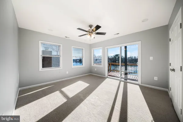 a view of a room with a ceiling fan and window