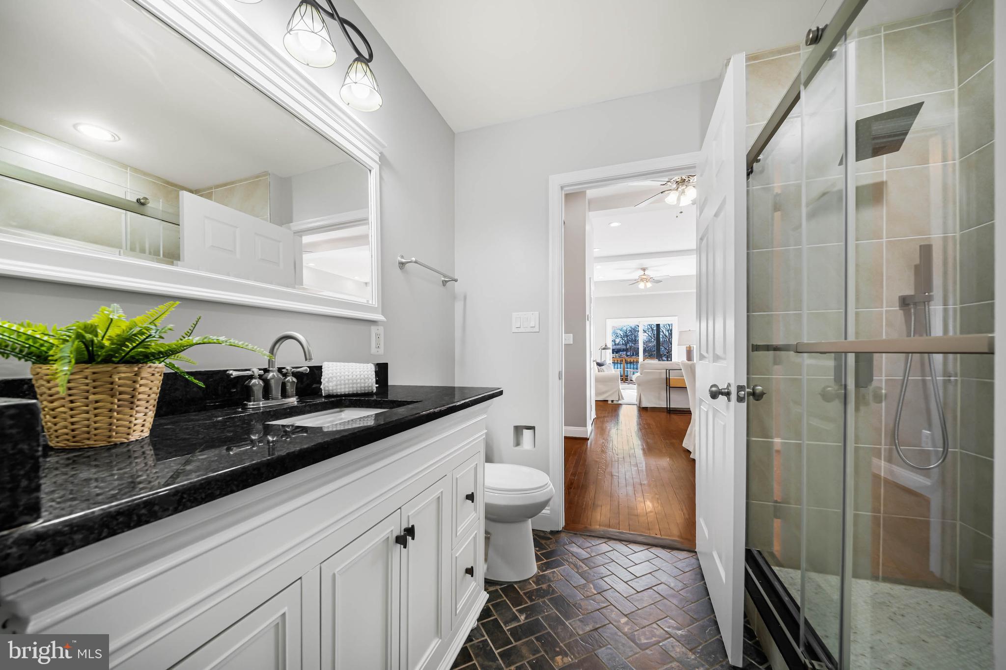 8101 Shore Road Baltimore, MD 21222 - Photo 23 of 35 a bathroom with a granite countertop sink a toilet a mirror and shower