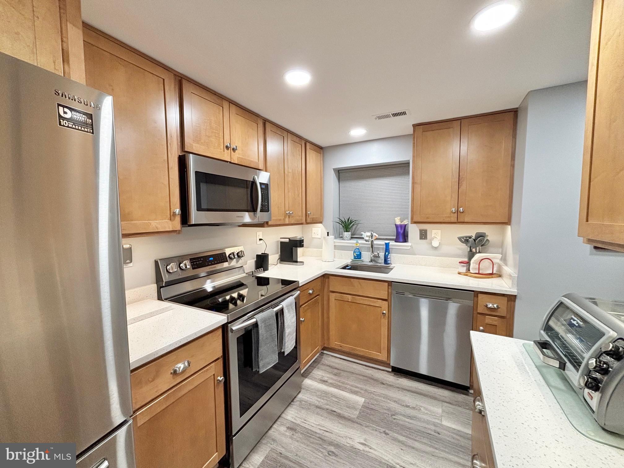 a kitchen with granite countertop a sink stove and refrigerator