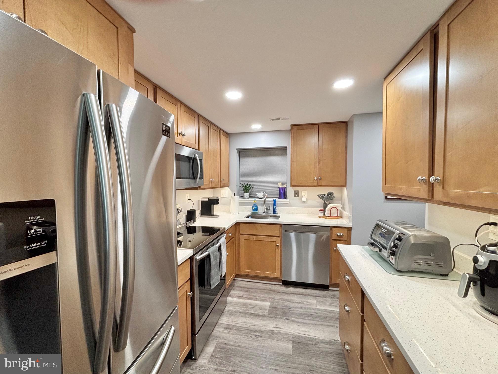 15111 Glade Drive, Unit 123D Silver Spring, MD 20906 - Photo 7 of 23 a kitchen with a sink stainless steel appliances and cabinets